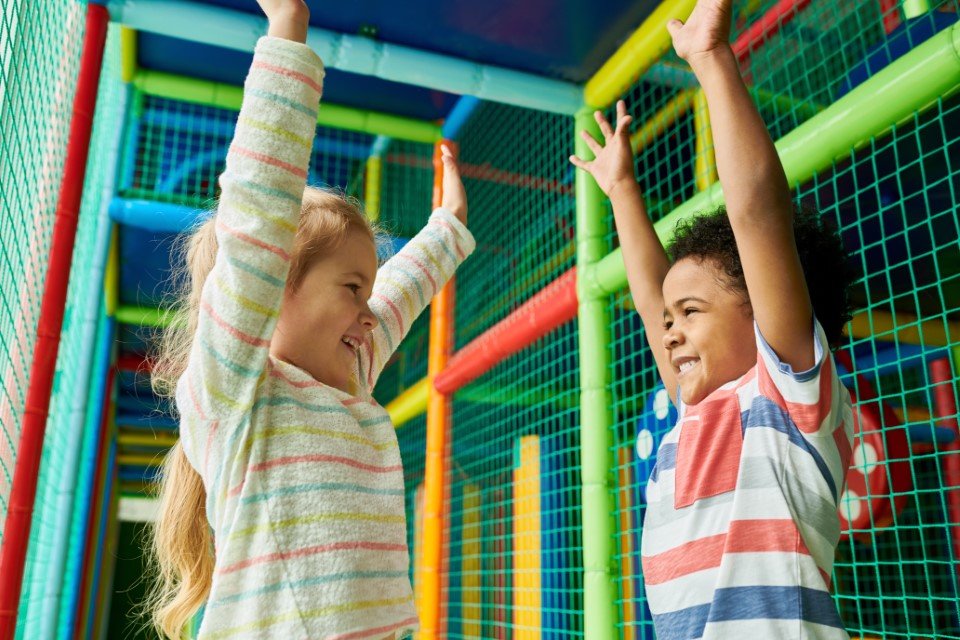 two kids in a soft play frame
