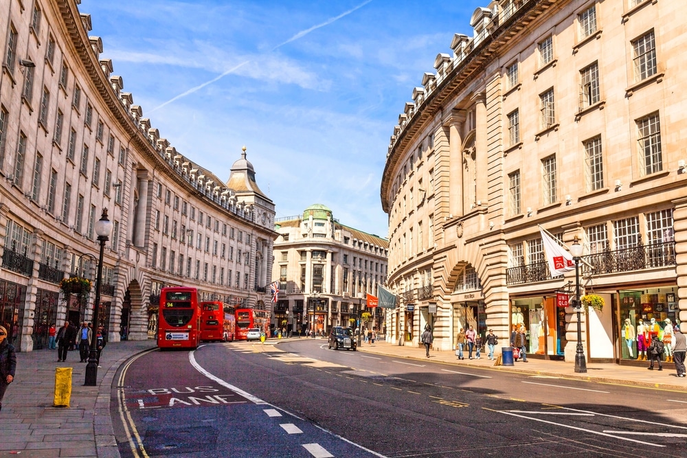 london high street with red double decker buses lined up