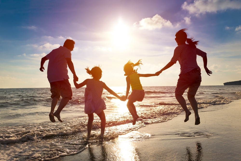 family on a beach jumping