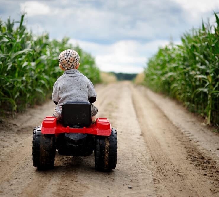 little boy on a mini tractor