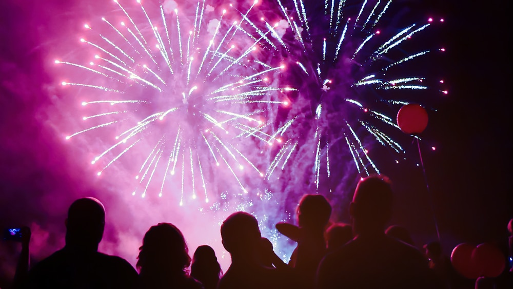 people watching pink fireworks