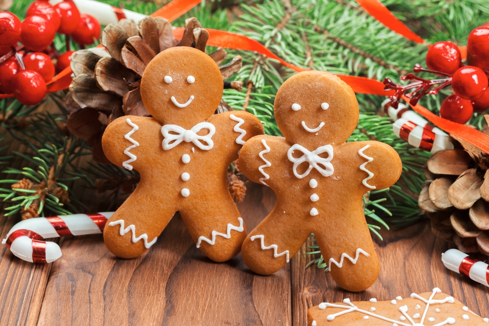 two gingerbread men among festive decorations and candy cane