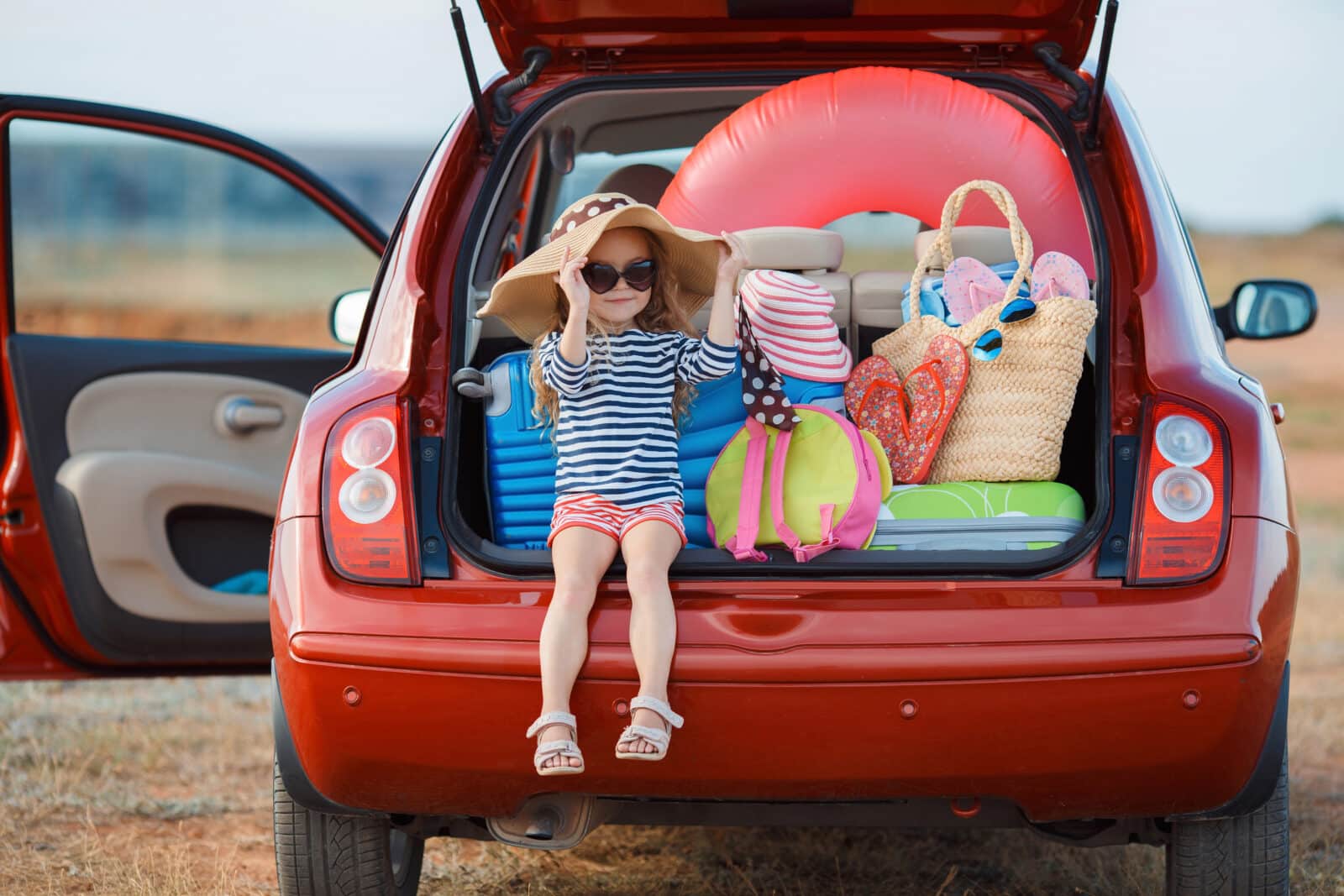 Girl in car with suitcases