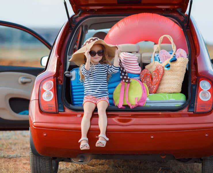 Girl in car with suitcases