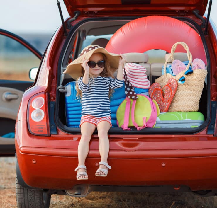 Girl in car with suitcases
