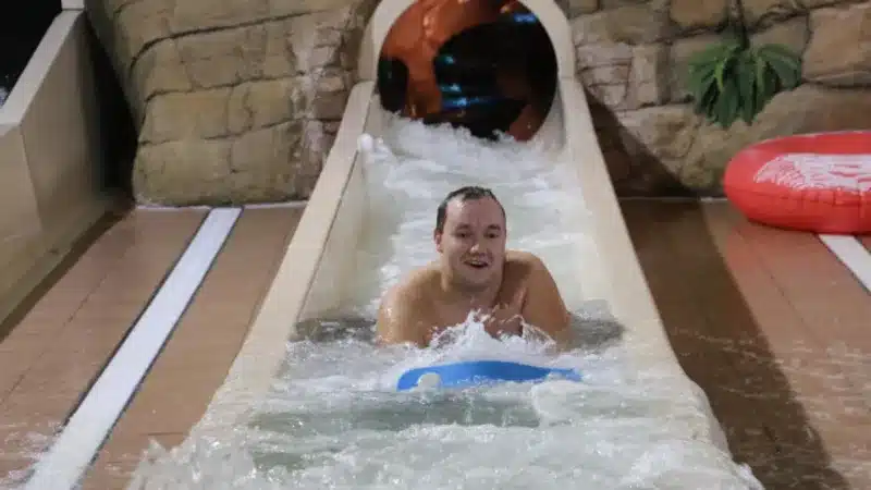 man sliding down water flume