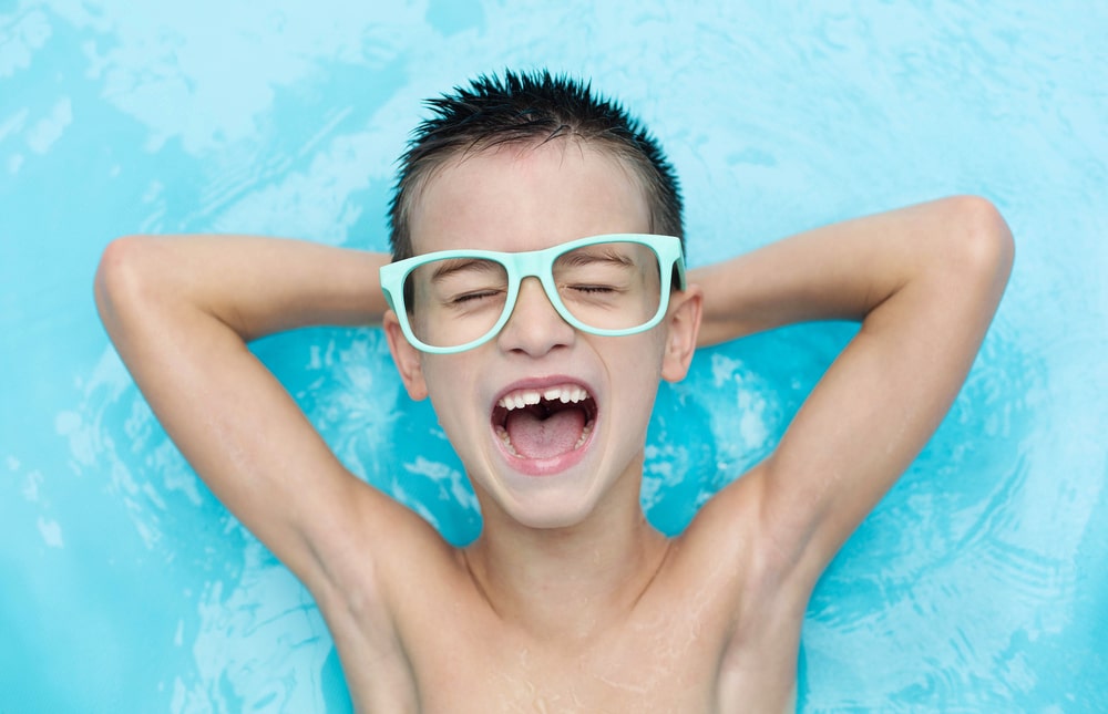 boy smiling while floating on water