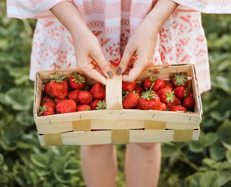 girl with a crate of strawberries