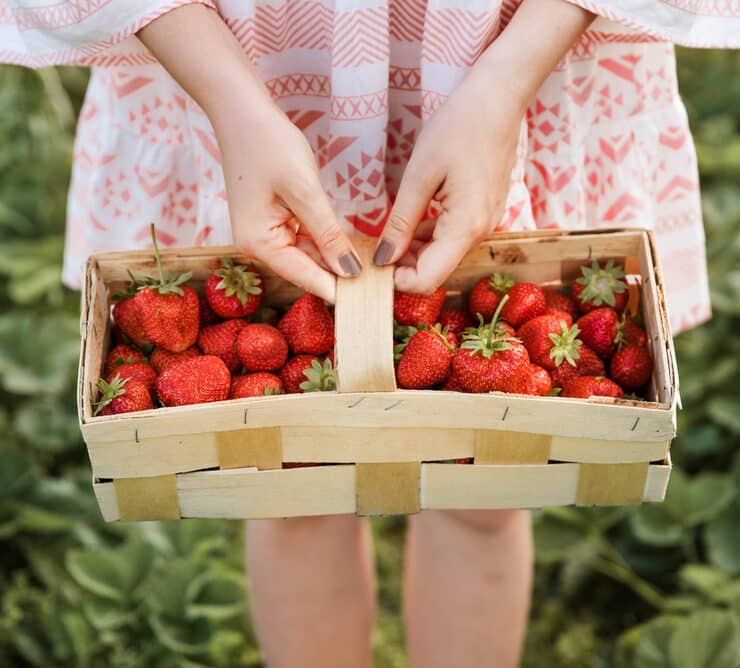 girl with a crate of strawberries