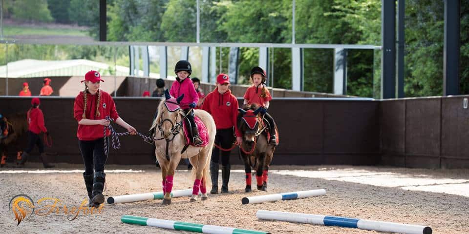 Children learning to ride horses in Cannock
