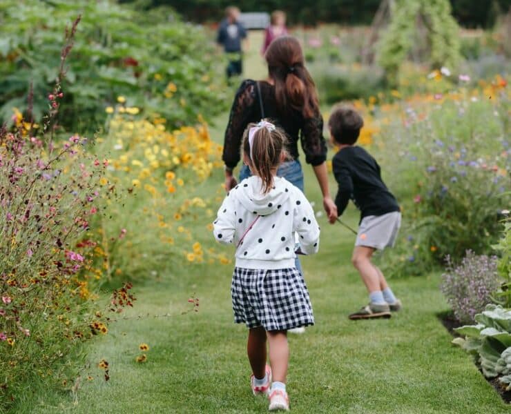 a family walking through the garden of wisley