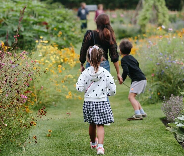 a family walking through the garden of wisley