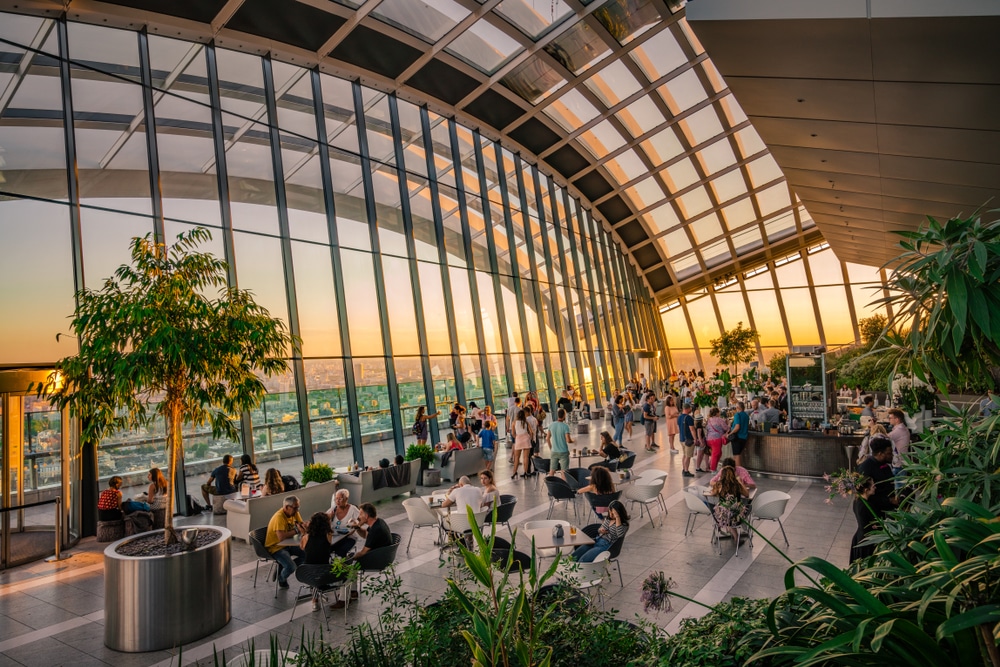 picture of sky garden with the view of the skyline and plants around the tables