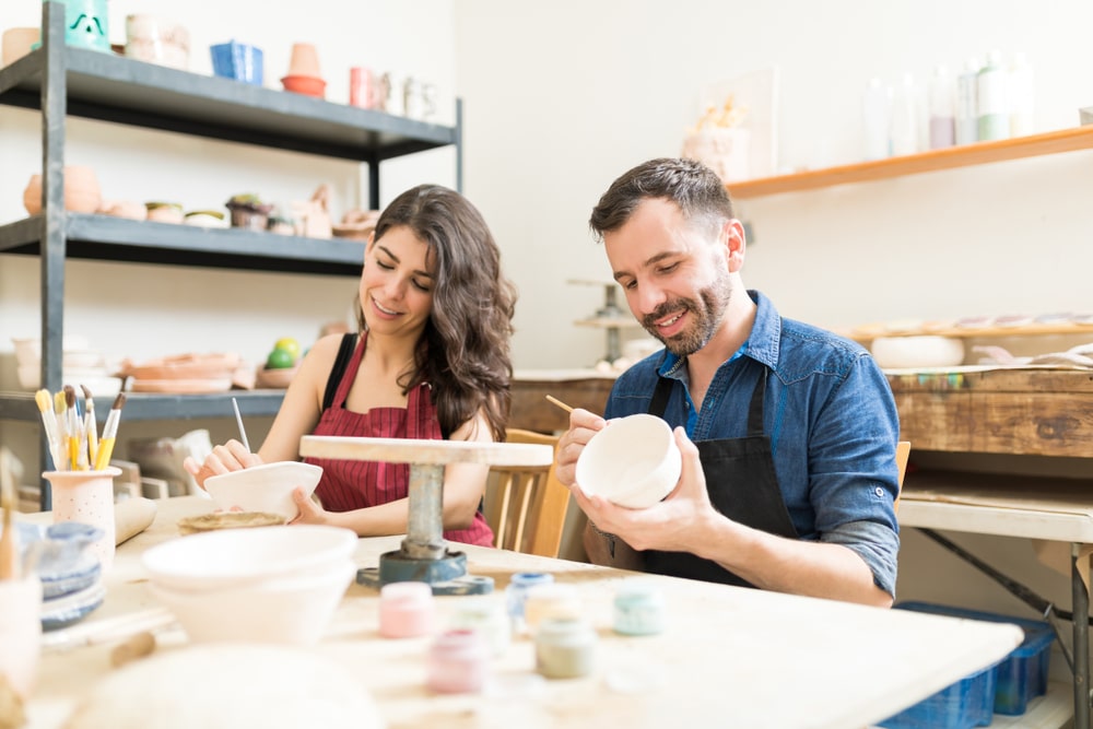 adults painting pottery