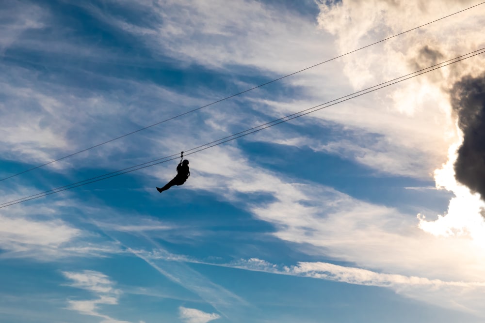 man zip lining in the sky