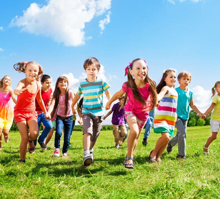 bunch of kids running on grass