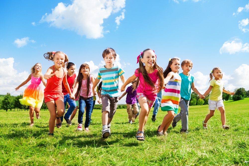 bunch of kids running on grass
