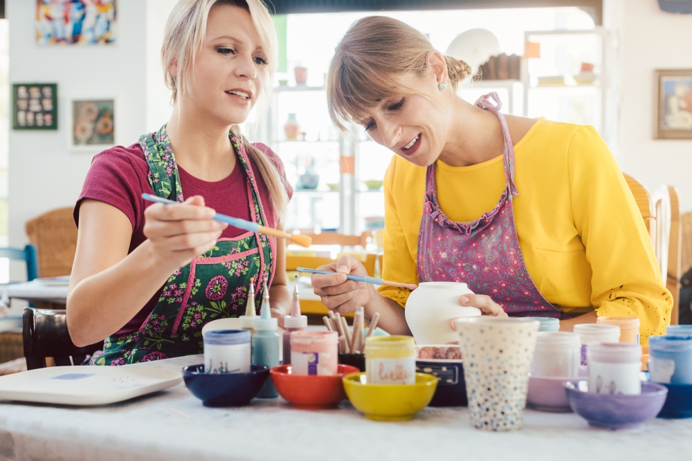 adults painting pottery