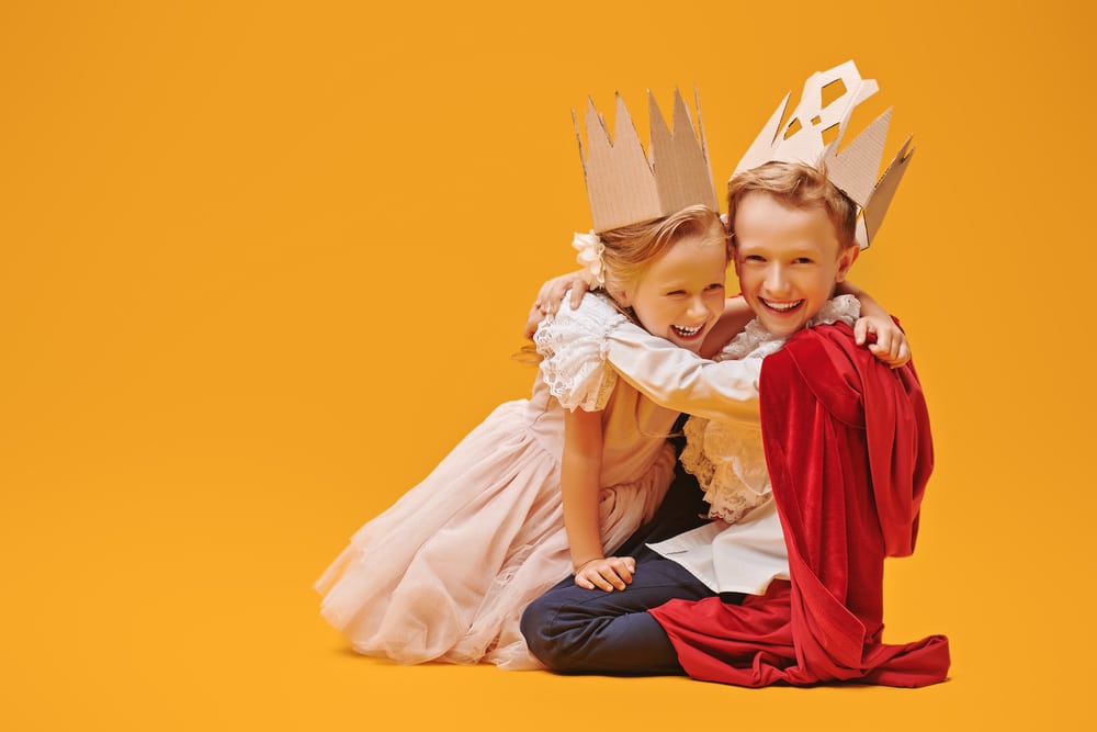 two kids dressed up as a prince and princess with crowns