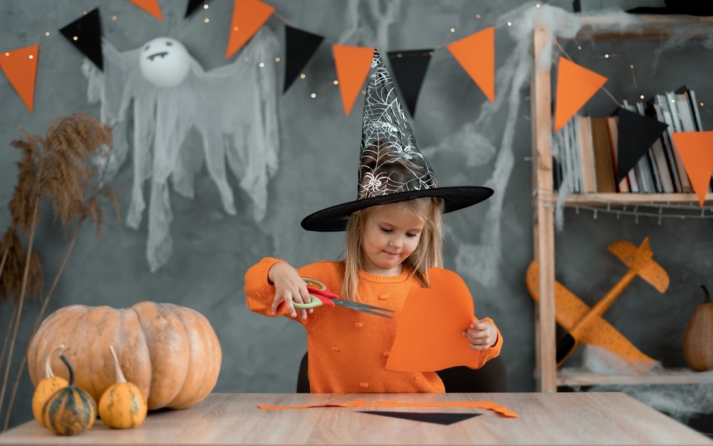 child making homemade halloween decorations