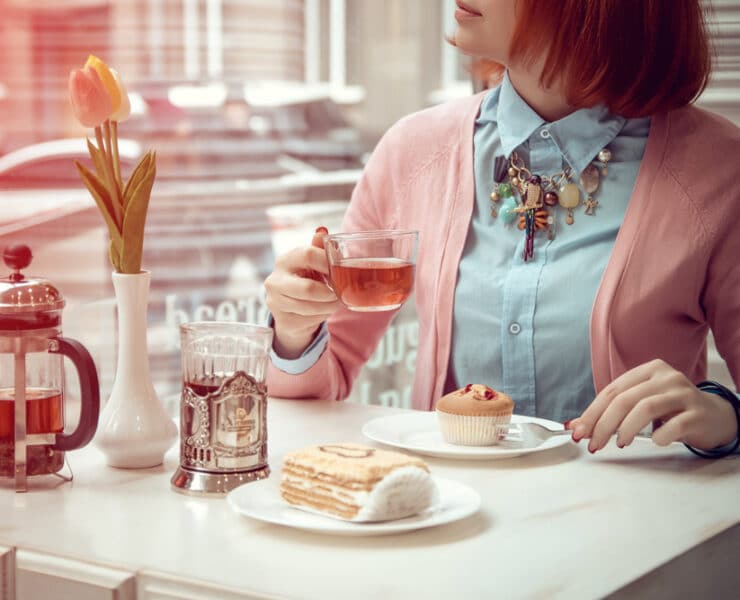 woman drinking tea and eating a dessert