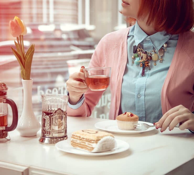 woman drinking tea and eating a dessert