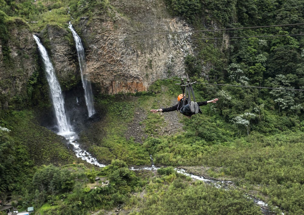 a person zip wiring over a river and rocks