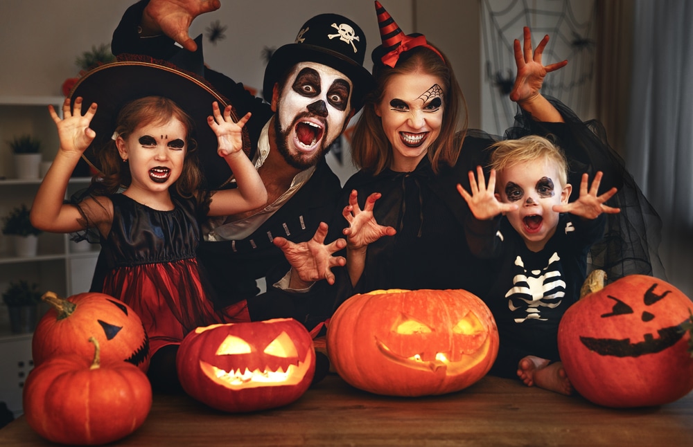 family dressed up in halloween clothes with pumpkins around them