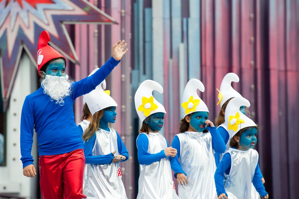children dressed up as Smurfs with blue painted faces and white hats