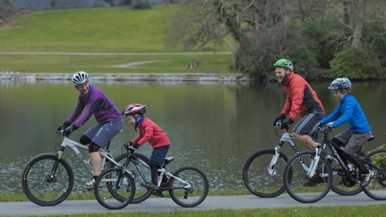 a family cycling along a lake