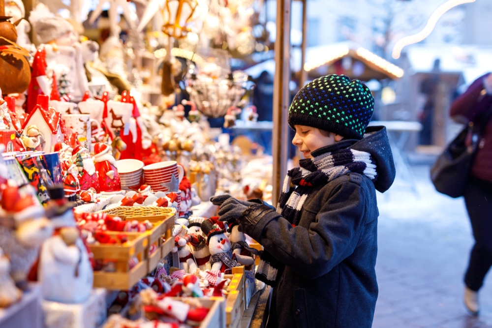 boy looking at sweets in at a christmas market stalll