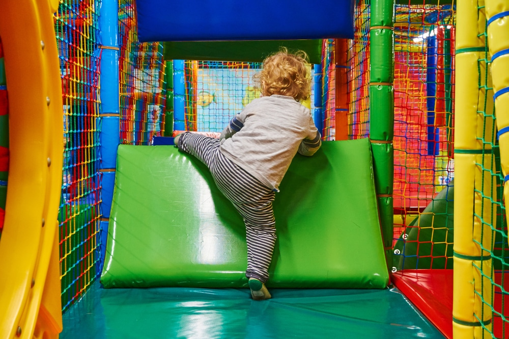 kid climbing wall in softplay