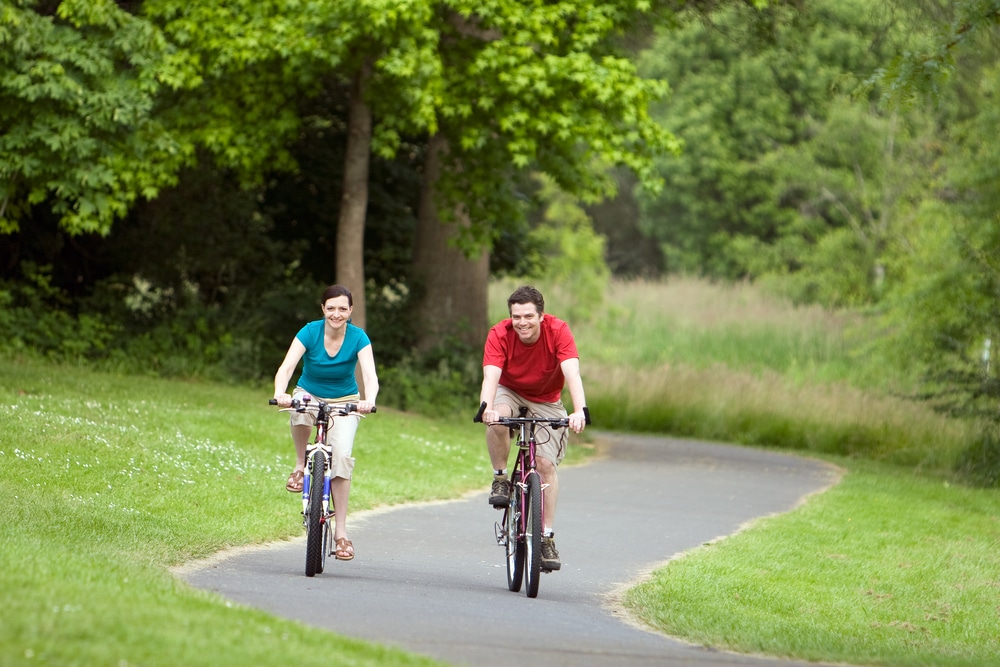 two people cycling in a park