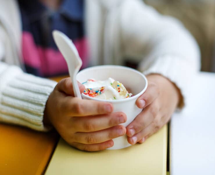 Kid holding cup of frozen yoghurt