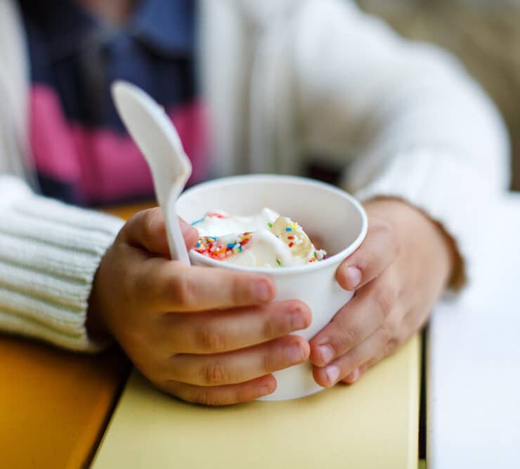 Kid holding cup of frozen yoghurt