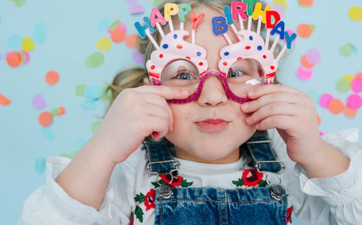 little girl wearing happy birthday glasses