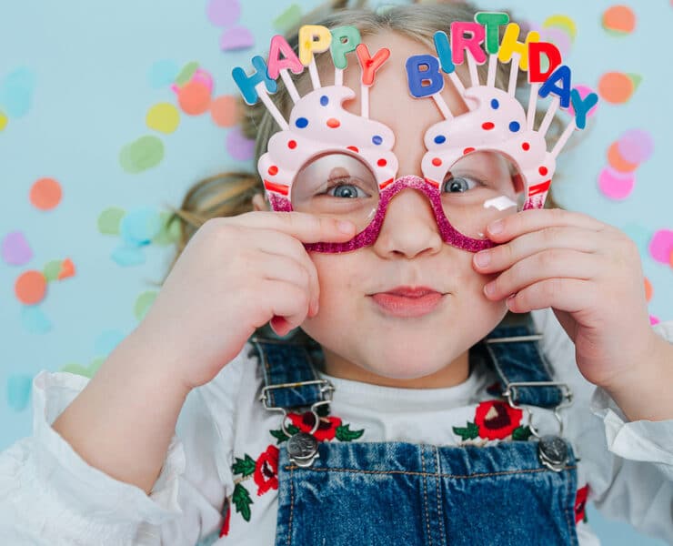 little girl wearing happy birthday glasses