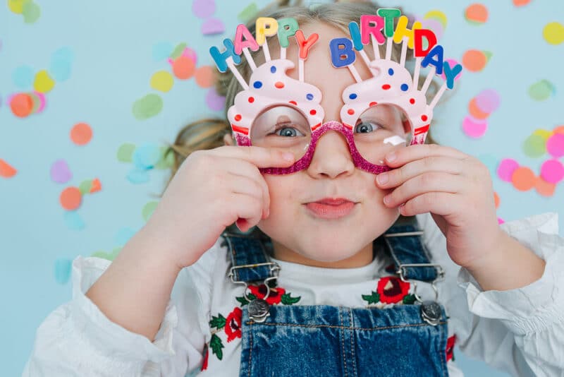 little girl wearing happy birthday glasses