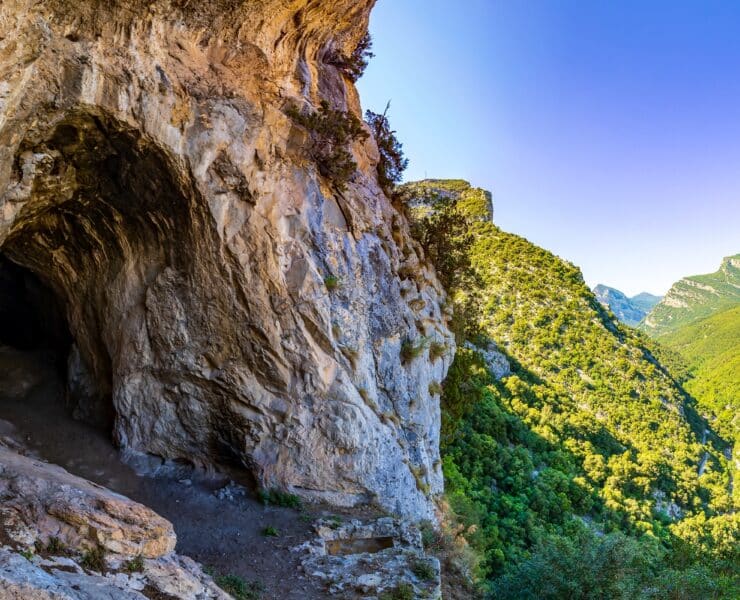 Cave surrounded by green mountains