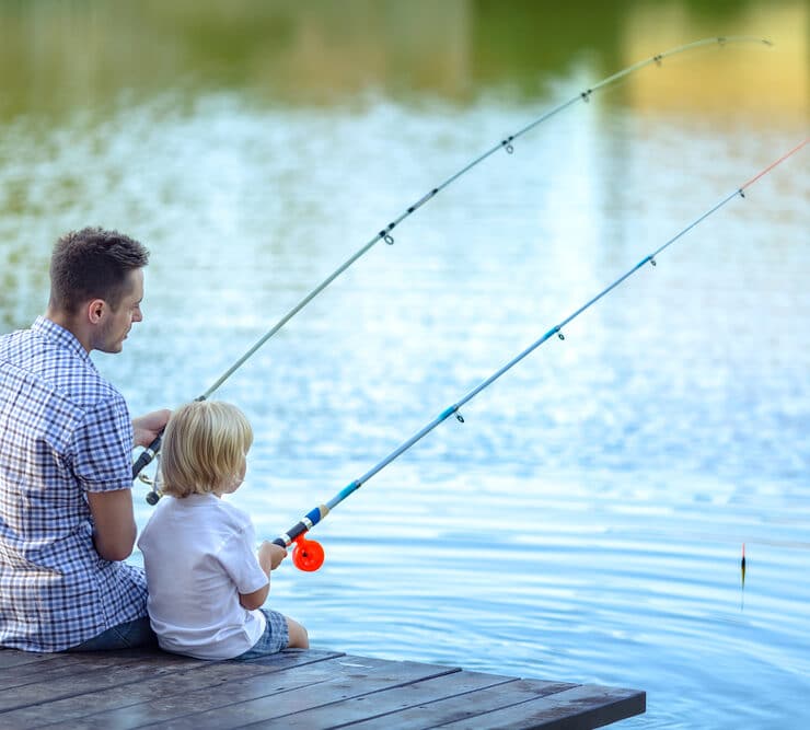 dad and son fishing in a lake