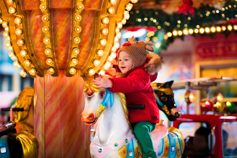 young child on christmas carousel