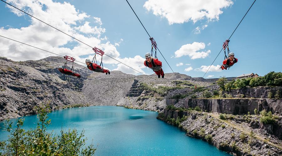 4 people zooming over a blue lake