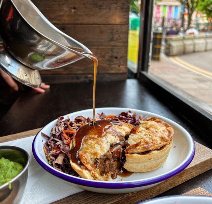 Gravy being poured over pie in Pieminister Birmingham