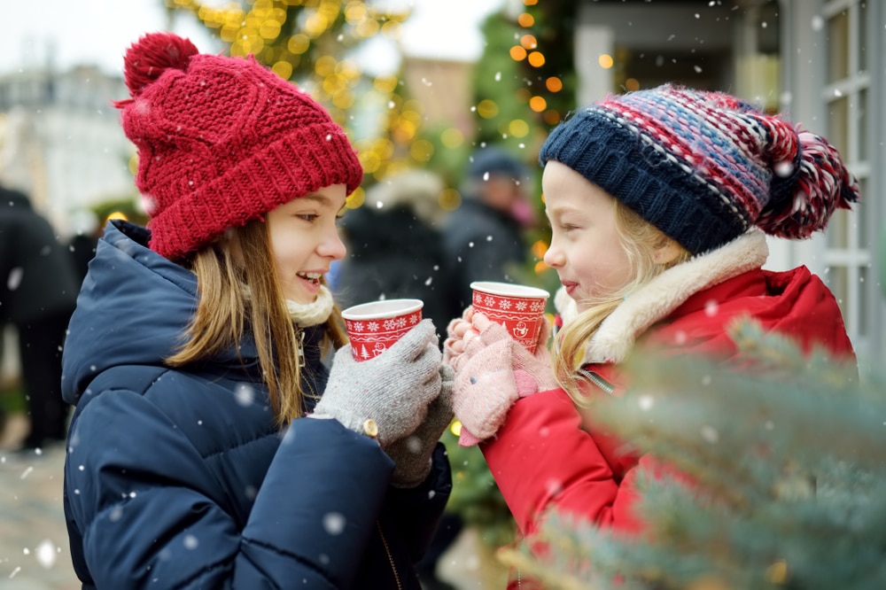 girls drinking hot chocolate and laughing in the snow