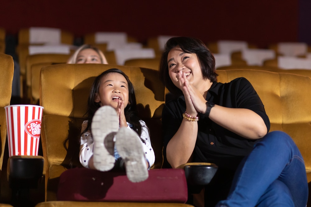 mother and child gasping in audience chairs at theatre