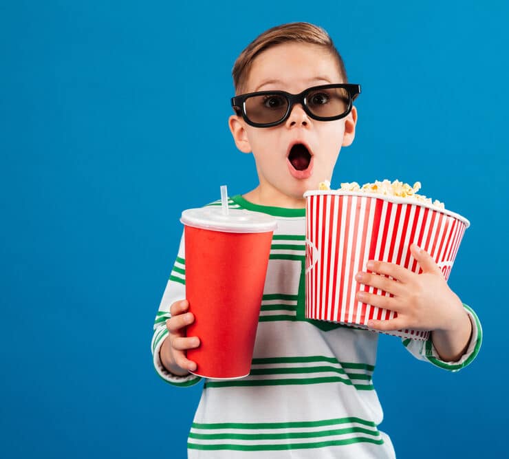 child holding a popcorn tub and big drink