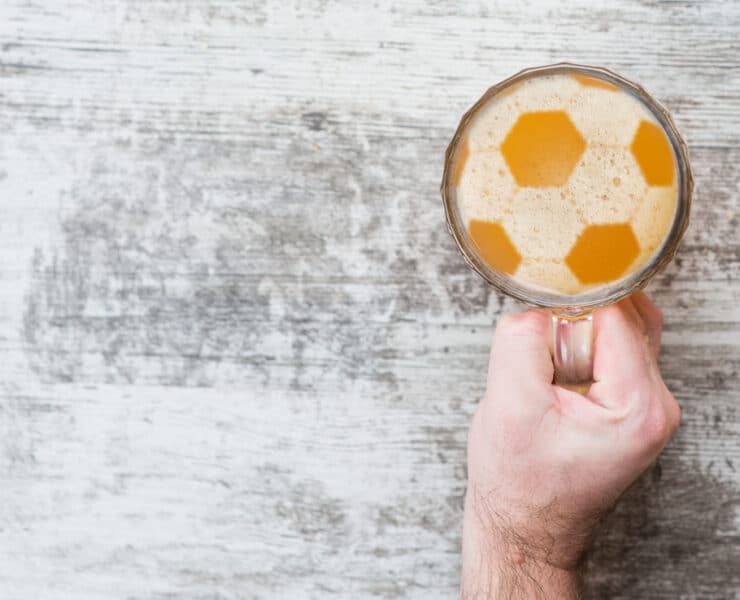a pint of beer with bubbles in the shape of a football