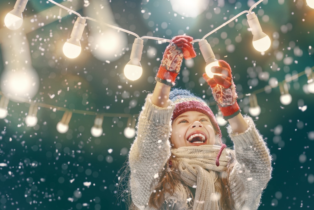 little girl holding fairy lights
