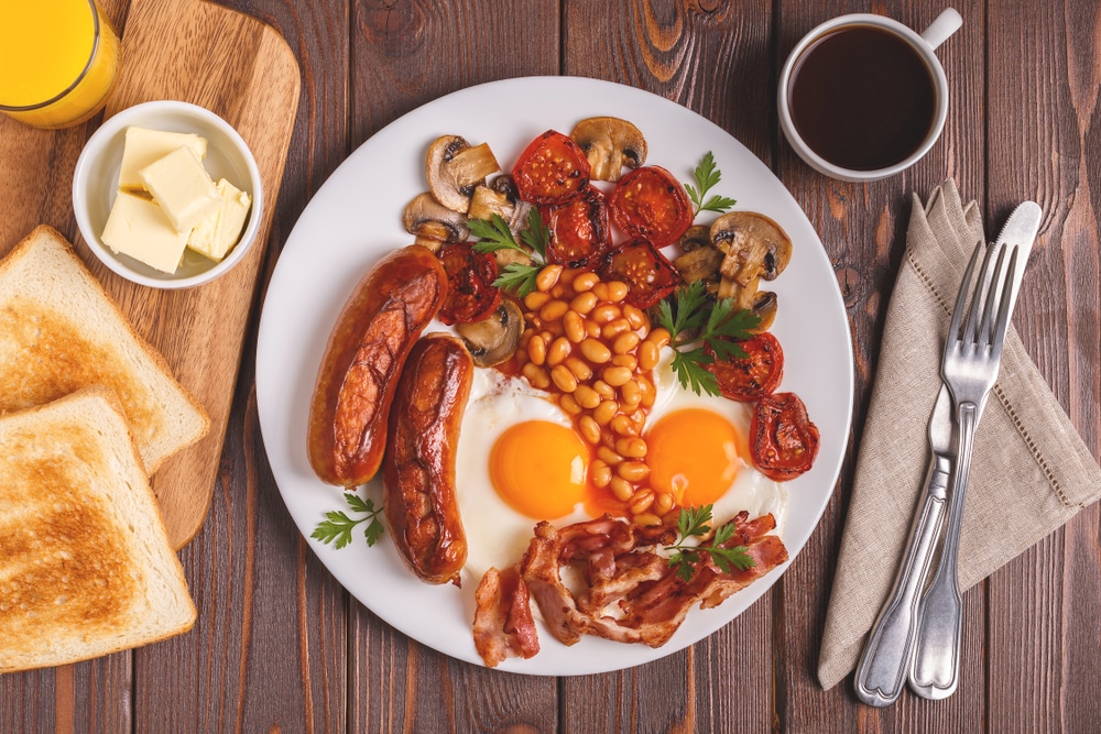 a plate of eggs, beans, sausages and mushrooms for breakfast