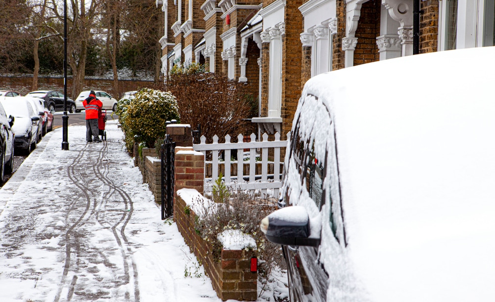 Royal Mail postal worker walking down a snow covered street